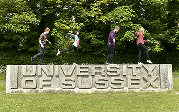 Students standing on the ɫ entrance sign