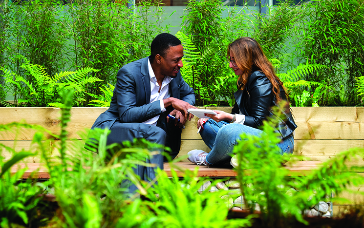A business man and a colleague discussing a topic in a meeting in an outside space at the ɫ